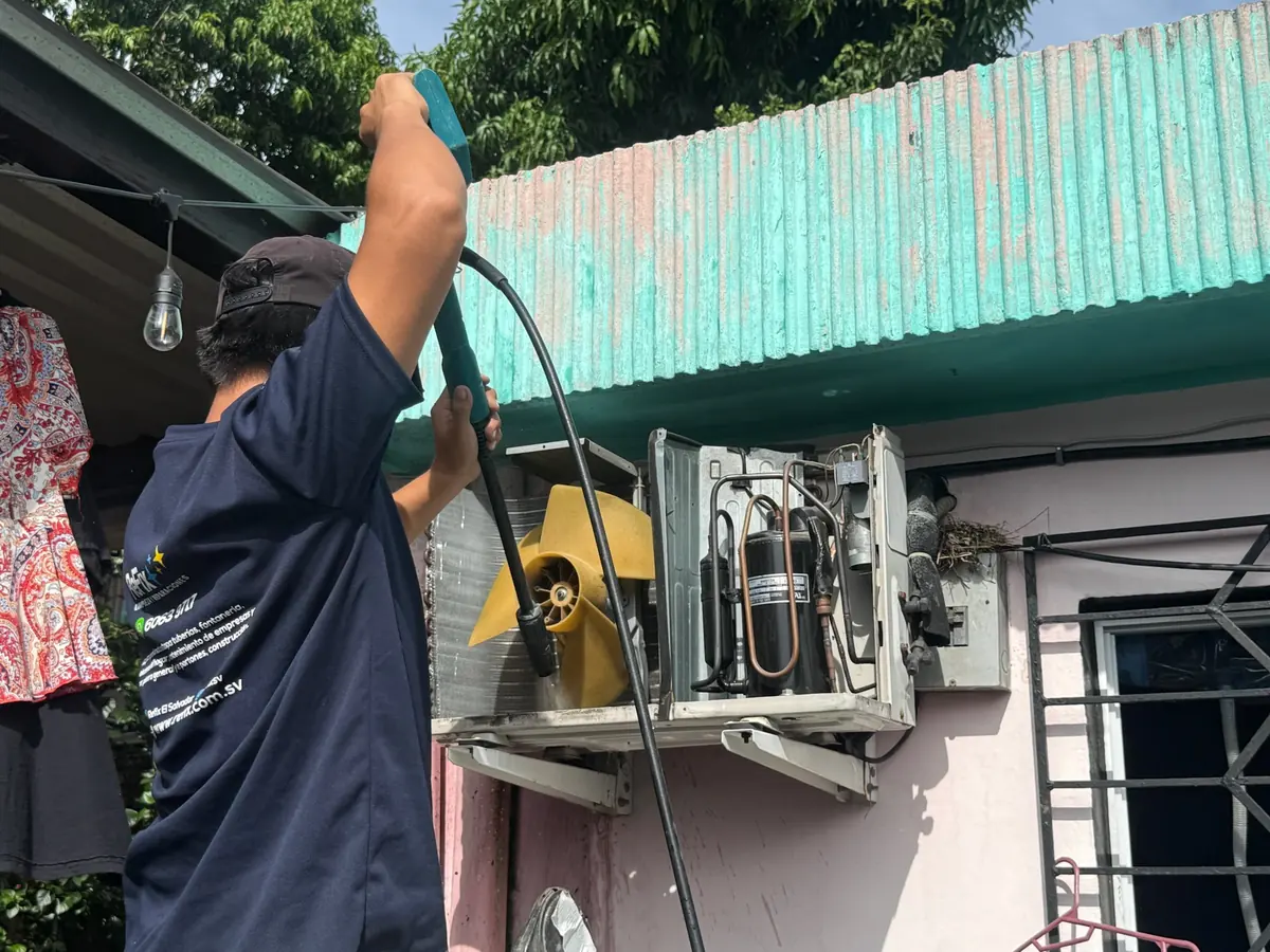 Técnicos de ReFix lavando la unidad exterior de un aire acondicionado