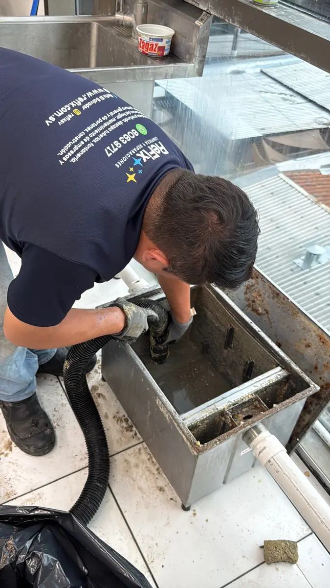 Técnico de ReFix limpiando una trampa de grasa con equipo de succión