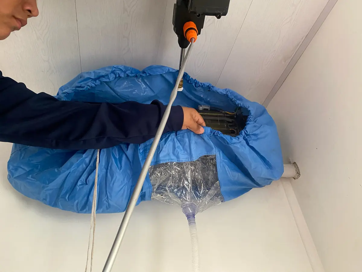 Lavado a presión de un aire acondicionado con bolsa colectora azul