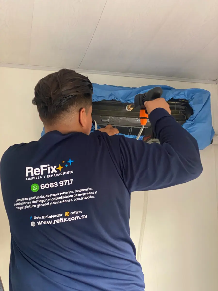 Técnico de ReFix lavando un aire acondicionado con bolsa colectora